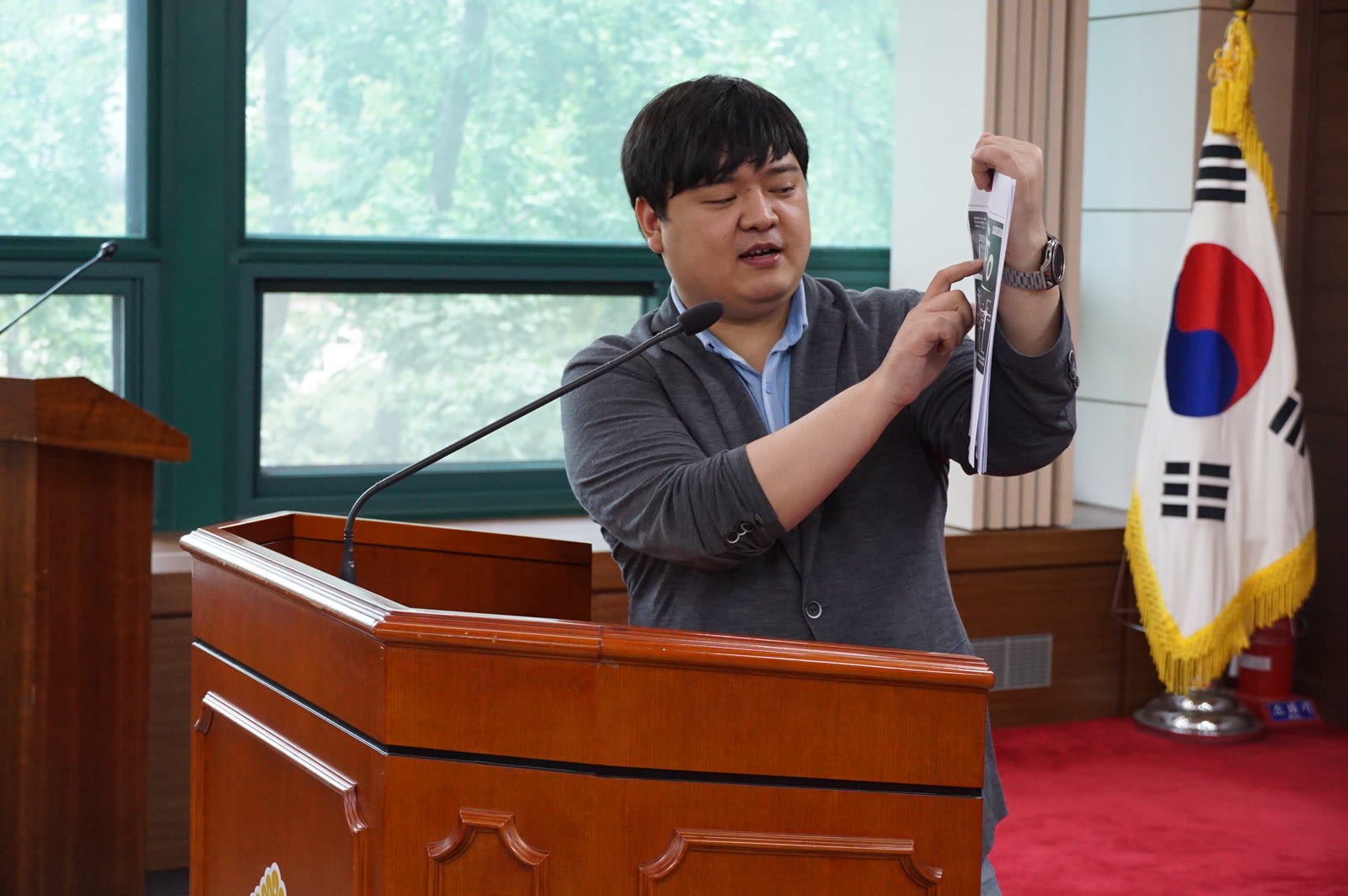 서울시의회 강연에서 자료를 들어 설명하는 이민우 원장
